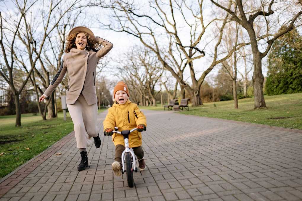 Femme et enfant en mouvement sur un chemin de briques dans un parc