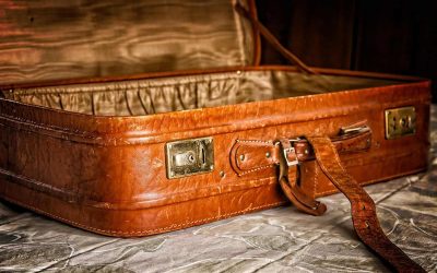 Un suitcase en cuir ouvert posé sur un tissu froissé