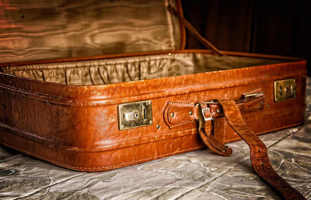 Un suitcase en cuir ouvert posé sur un tissu froissé