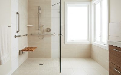 Salle de bain accessible senior, douche de plain-pied avec barre d'appui et siège, carrelage clair, lumineuse