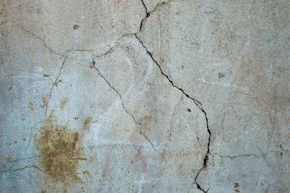 Mur de béton avec fissures et taches d’humidité