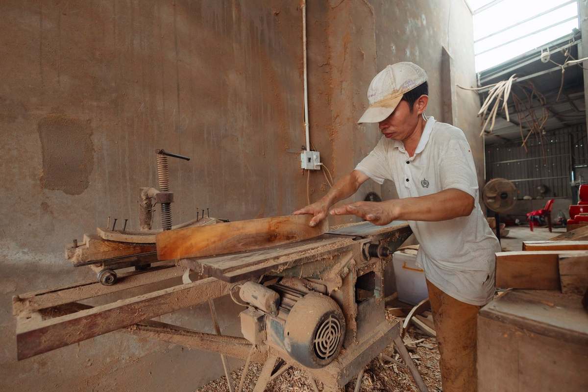 Homme en atelier, scie à table, planche de bois, sciage en cours